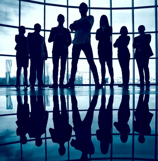 Business team standing against window with leader in front